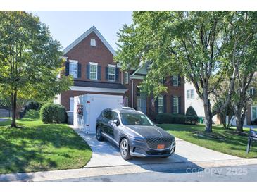 Charming two-story brick home with a well-manicured lawn, driveway, and modern grey SUV parked in front at 6416 Red Maple Dr, Charlotte, NC 28277