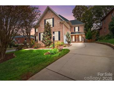 Brick home with landscaped yard, driveway, and charming architectural details at 5303 Shasta Hill Ct, Charlotte, NC 28211