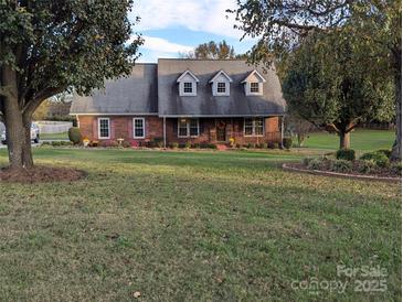 Charming brick home with a well-manicured lawn and inviting front porch at 2304 Fox Hunt Dr, Monroe, NC 28110