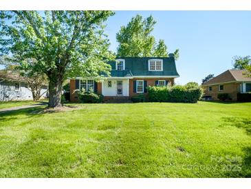 Charming two-story brick home with a lush green lawn and mature shade tree, offering classic curb appeal at 1018 Carysbrook Ln, Charlotte, NC 28217