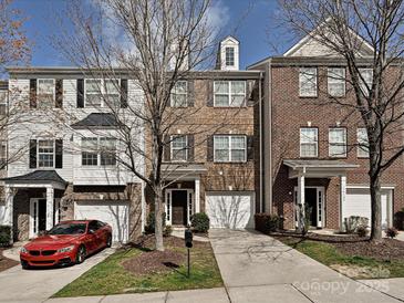 Traditional townhome showcasing multi-tone brickwork, attached garages, and bare trees enhancing its curb appeal at 14121 Winford Ln, Charlotte, NC 28262