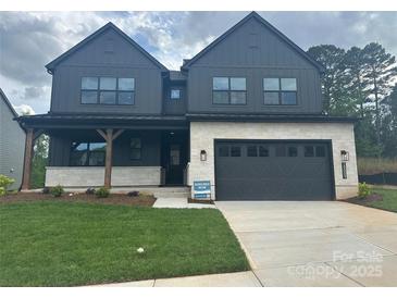 Beautiful two story home featuring a front porch, well-manicured lawn, and a two-car garage at 15009 Brownleigh Ln # 26, Huntersville, NC 28078