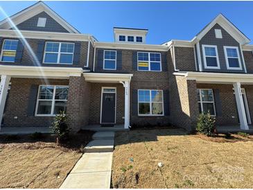 Attractive brick townhome featuring gray shutters, manicured lawn, and inviting entrance at 5540 Stafford Rd # 31, Charlotte, NC 28215