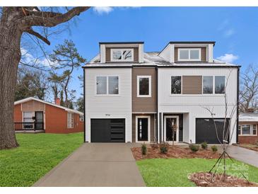 Modern townhome featuring a black garage door, sleek exterior, and well-manicured lawn at 1916 Irma St, Charlotte, NC 28216