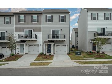 Modern townhome featuring a small balcony and a single-car garage in a residential neighborhood at 13047 Gadwal Pintail Dr, Charlotte, NC 28262