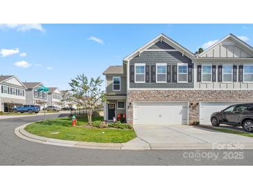 Two-story townhome with gray siding, two-car garage, and landscaping at 3878 Fairlady Ln, Fort Mill, SC 29707