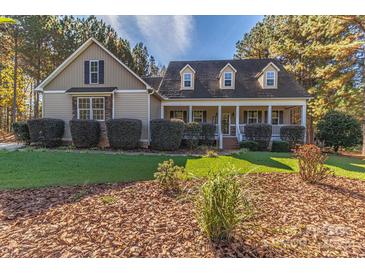 House exterior featuring a two-story home with a wraparound porch, landscaping, and stone accents at 360 Lauren Pines Dr, York, SC 29745