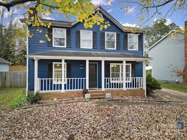 Two-story blue house with white trim, porch, and landscaping at 6934 Spring Morning Ln, Charlotte, NC 28227