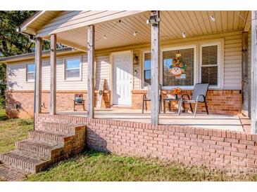 Inviting front porch with brick steps, wooden posts, and seating area at 316 Brawley Rd, Cleveland, NC 27013