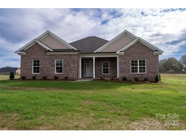 Charming brick home with a well-manicured lawn and a covered front porch with white columns and light landscaping at 3034 Buffet Ln, Monroe, NC 28110