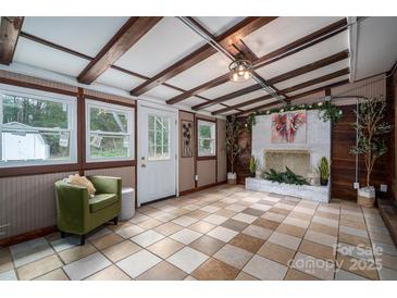 Cozy sunroom featuring wood beams, tiled floor, and a decorative fireplace at 231 Cheek Rd, Clover, SC 29710