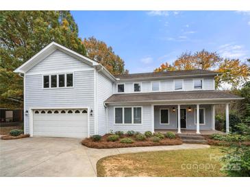 Traditional two-story home featuring a two car garage, covered front porch, and beautiful fall foliage at 2545 Rea Rd, Charlotte, NC 28226