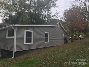 Home exterior featuring gray siding, white trim, and well-maintained landscaping at 605 N Mcfarland N St, Gastonia, NC 28054