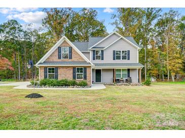 Charming two-story home featuring brick and gray siding, complemented by a well-manicured lawn and mature trees at 3018 Corinth Church Rd, Monroe, NC 28112