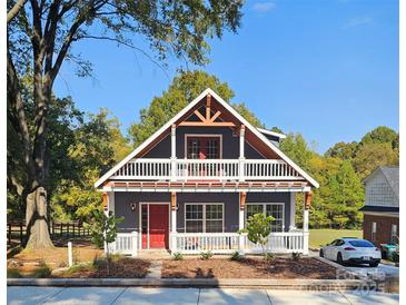 Two-story house with a gray exterior, red door, and wrap-around porch at 1703 Polk St, Monroe, NC 28110