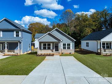 Charming gray home with inviting curb appeal, concrete driveway, and well-manicured lawn at 606 Meadow Ave, Spencer, NC 28159