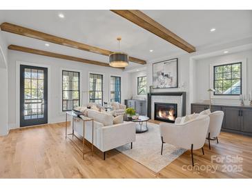 Spacious living room with wood beams, fireplace, and hardwood floors at 705 Mcalway Rd, Charlotte, NC 28211