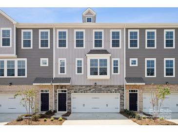 Three-unit townhome building with gray siding, brick accents, and two-car garages at 4375 Reed Creek Dr, Sherrills Ford, NC 28673