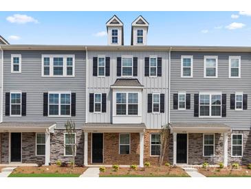 Three-story townhome with gray siding, brick accents, and two-car garage at 7121 Brookview Ln, Sherrills Ford, NC 28673