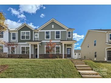 Two-story townhome with green siding, brick accents, and a landscaped lawn at 9744 Inkberry Dr, Gastonia, NC 28056