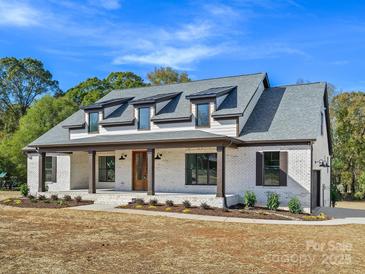 Charming home featuring a welcoming front porch, dormer windows, and a well-maintained lawn at 4539 Polk Ford Rd, Stanfield, NC 28163