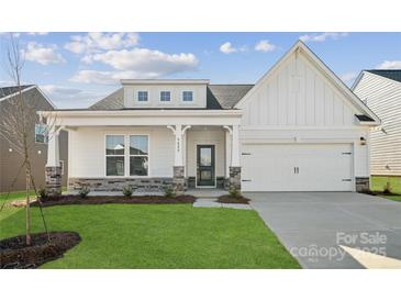 House exterior boasts a charming farmhouse design with stone accents and a two-car garage at 9088 El Sworth Dr, Sherrills Ford, NC 28673