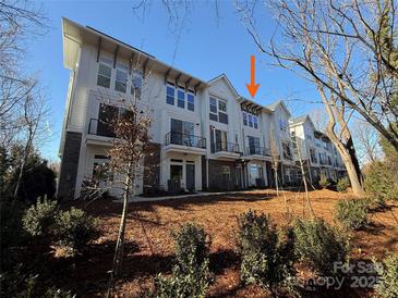 A row of modern townhomes showcases a blend of white siding and brick accents under a clear blue sky at 1419 Collier Walk Aly # Csw0208, Charlotte, NC 28205