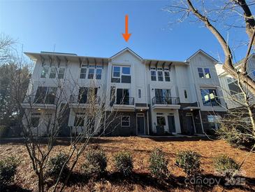 Charming townhome featuring a modern facade and inviting curb appeal, set against a clear blue sky at 1421 Collier Walk Aly # Csw0209, Charlotte, NC 28205