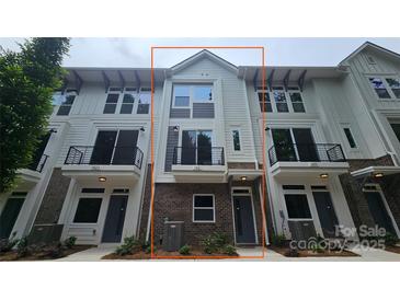 Modern townhouse with a mix of brick and siding, featuring black metal balconies, ample windows, and a welcoming entrance at 1421 Collier Walk Aly # Csw0209, Charlotte, NC 28205