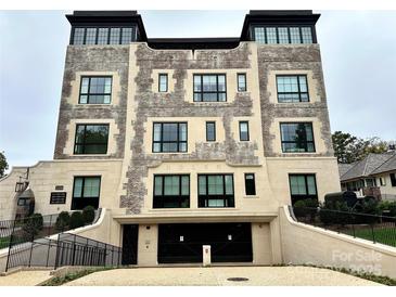 Stunning exterior view with brick and stone details and drive-under garage at 1168 Queens Rd, Charlotte, NC 28207