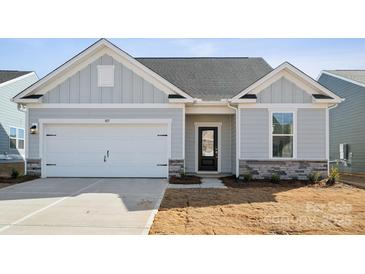 Charming single-story home featuring a two-car garage, stone accents, and a well-manicured front yard at 885 Exeter Dr, Sherrills Ford, NC 28673