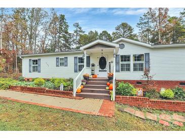 Charming single-story home with well-manicured landscaping and a welcoming front porch decorated for fall at 2164 Mission Rd, York, SC 29745