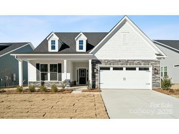 Craftsman style home with gray stone accents and a covered porch at 3118 Whispering Creek Dr, Indian Trail, NC 28079