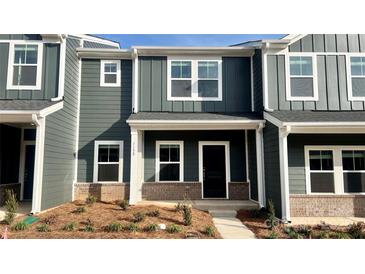 New construction townhome with gray siding, brick accents and a covered entryway at 115 Ciara Pl # B, Mooresville, NC 28117