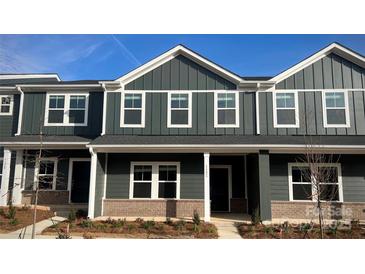 Charming townhome with a modern facade featuring a brick foundation and stylish white trim at 115 Ciara Pl # C, Mooresville, NC 28117