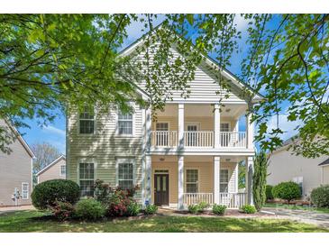 Charming two-story home featuring a double front porch and beautifully landscaped front yard at 18023 Train Station Dr, Cornelius, NC 28031