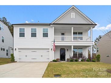 Charming two-story home featuring a welcoming front porch and attached two-car garage at 122 W Heart Pine Ln, Statesville, NC 28677