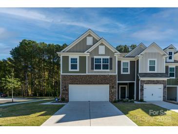 Two-story townhome with brick and siding, two-car garage, and landscaped lawn at 278 Harpers Run Ln, Matthews, NC 28104