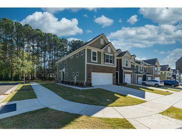 Two-story townhome with green siding, brick accents, and a two-car garage at 278 Harpers Run Ln, Matthews, NC 28104