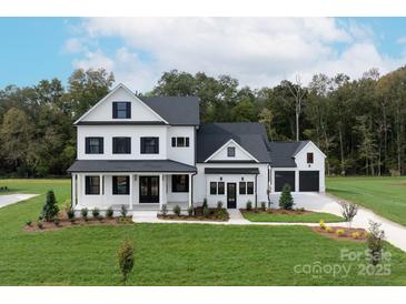 Two-story farmhouse with a white exterior, black shutters, and a three-car garage at 1325 Ballard Dr, Waxhaw, NC 28173