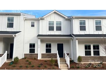 Charming two-story townhome featuring white siding, a dark front door, and a welcoming entryway at 105 Ciara Pl # B, Mooresville, NC 28117