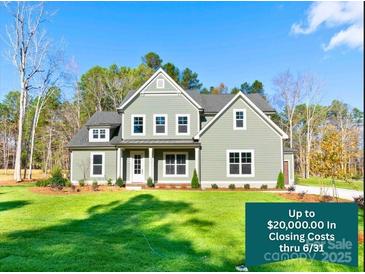 Charming two-story home featuring manicured lawn, complemented by verdant trees under clear blue skies at 1865 Rock Hill Church Rd # 3, Matthews, NC 28104