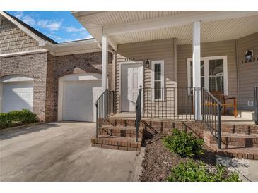 Charming home featuring a brick facade, inviting front porch, and attached two-car garage at 18819 Cloverstone Cir, Cornelius, NC 28031