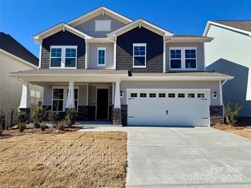 Two-story home featuring gray and blue siding, white trim, a two-car garage, and stone accents on the columns at 3031 Puddle Pond Rd, Indian Trail, NC 28079