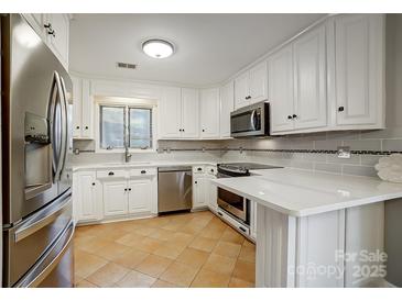 Modern kitchen with white cabinets, stainless steel appliances, and tile floor at 1500 Beth Haven Church Rd, Denver, NC 28037