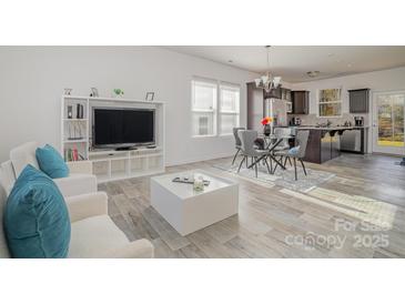 Bright and airy living room featuring modern furnishings, a large TV, and an open layout to the kitchen at 2507 Andes Dr, Statesville, NC 28625