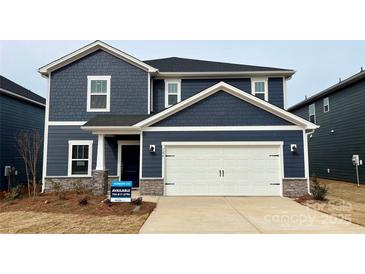 Two-story home with navy blue siding, white garage door, and landscaping at 106 Obadiah Ct, Troutman, NC 28115