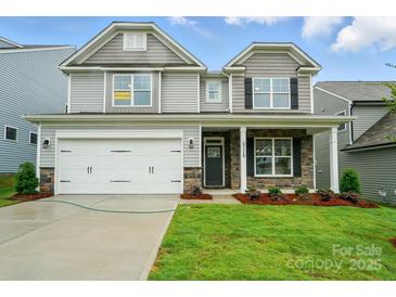 Charming two-story home featuring stone accents, a well-manicured lawn, and a two-car garage at 5115 Heathland Dr # 47, Charlotte, NC 28215