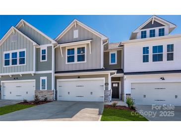 New two-story townhome featuring attached garage and neutral-tone siding with stone accents at 149 Halite Ln, Waxhaw, NC 28173