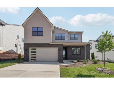 Two-story home featuring a brick facade, a two-car garage, and a manicured front lawn at 15008 Brownleigh Ln # 29, Huntersville, NC 28078